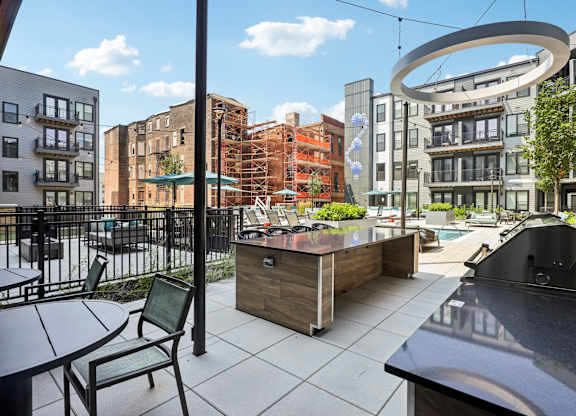 A patio with a table and chairs overlooks a city street.