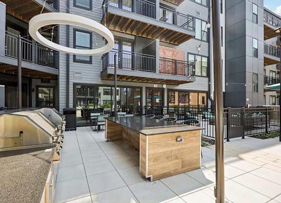 A modern outdoor kitchen area with a barbecue grill and seating area.