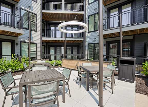 A patio with a table and chairs is surrounded by apartment buildings.