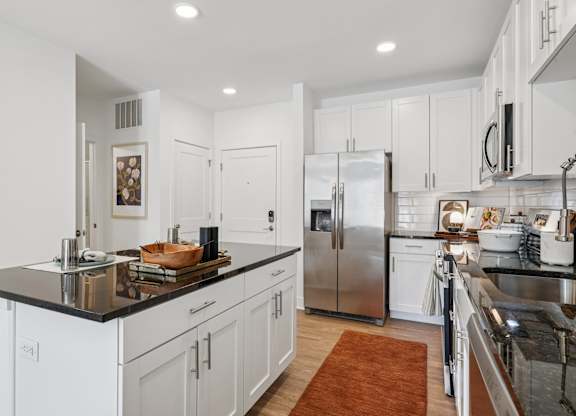 Open-concept kitchen and living area at Contrast OTR in Over-the-Rhine, Cincinnati with hardwood flooring and designer finishes.