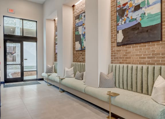 a living room with couches and a brick wall and a door