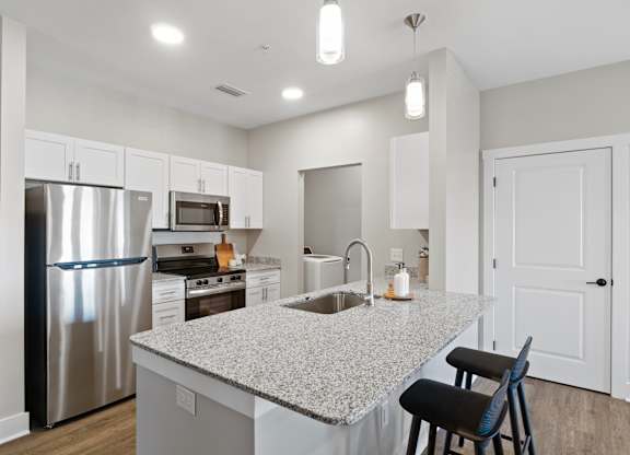 A kitchen with a granite countertop and stainless steel appliances.