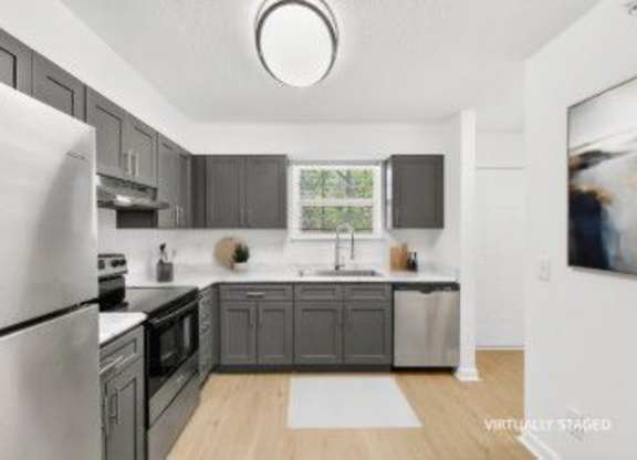 A modern kitchen with a refrigerator, oven, and sink.
