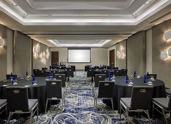 A conference room with black tables and chairs.