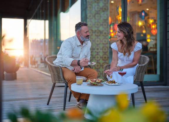 A man and a woman are having a meal together on a table.