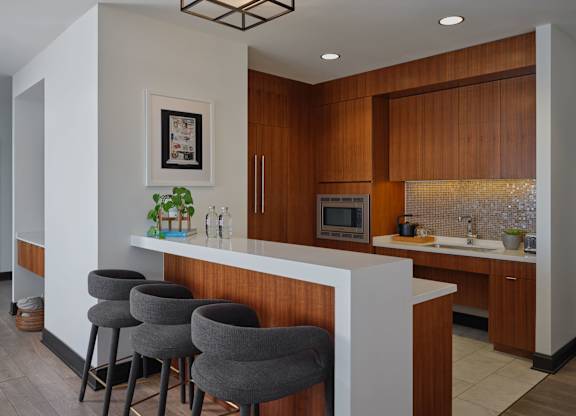 A kitchen with a white counter and brown cabinets.