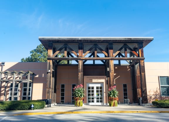 the front entrance of a building with a brown facade and pillars