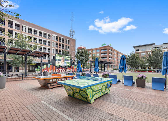 Park with ping pong table and umbrellas in city at Governor Square Apartments, Carmel, Indiana