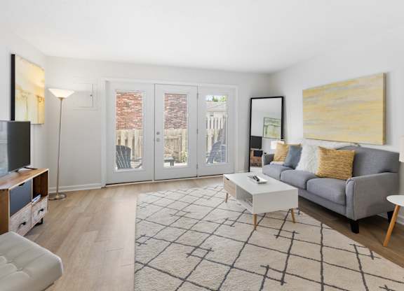 Modern living room at Monon Living in Broad Ripple featuring sleek furnishings, bright natural light, and direct access to a private patio near the Monon Trail.