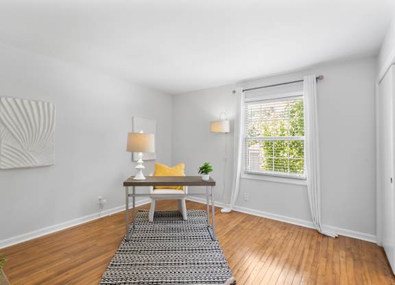 Spacious flex room at Monon Living with hardwood floors and natural light, ideal for a home office or guest space near the Monon Trail in Broad Ripple.