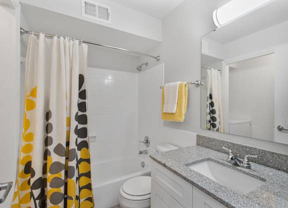 Stylish full bathroom at Monon Living in Broad Ripple featuring granite vanity, designer lighting, and modern tile just minutes from Monon Trail access.