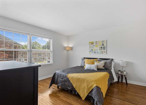 Primary bedroom at Monon Living with large windows and wood flooring, located in a walkable Broad Ripple community near Monon Trail bike access.