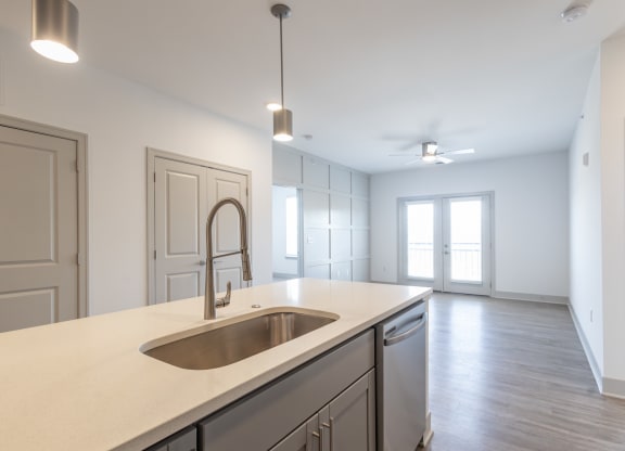 an empty kitchen with a sink and an empty living room