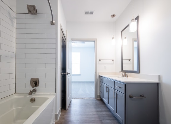 a bathroom with a tub and a sink and a mirror