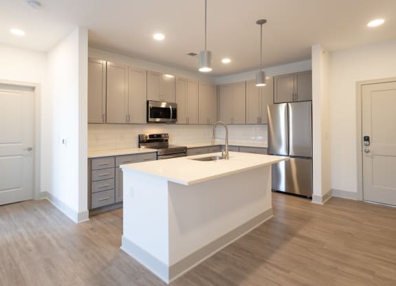 a kitchen with an island and a stainless steel refrigerator