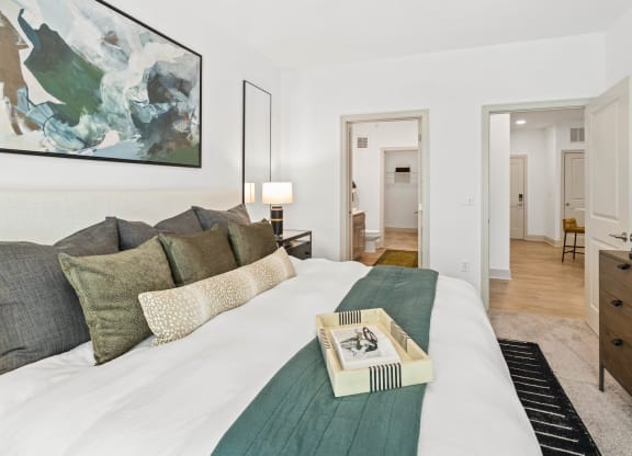 a bedroom with a large bed and a painting on the wall