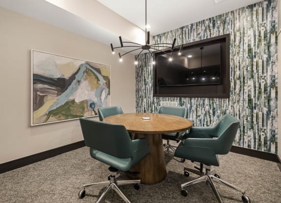 a conference room with a table and chairs and a television