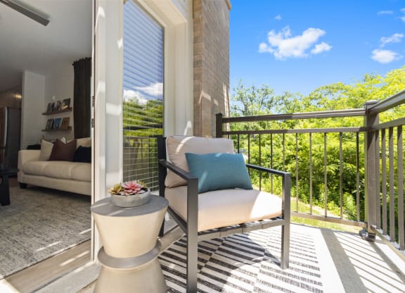 a patio with a chair and a table on a balcony