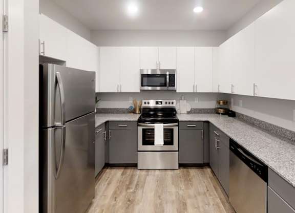 a kitchen with stainless steel appliances and granite counter tops at Echo Park at Perry Crossing Apartments, Plainfield, 46168