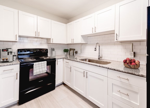 a kitchen with a black stove top oven next to a sink