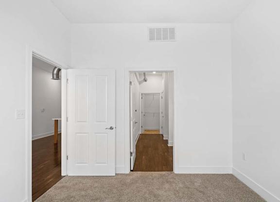 A white room with a carpeted floor and a doorway leading to another room.at The Foundry, South Bend Indiana