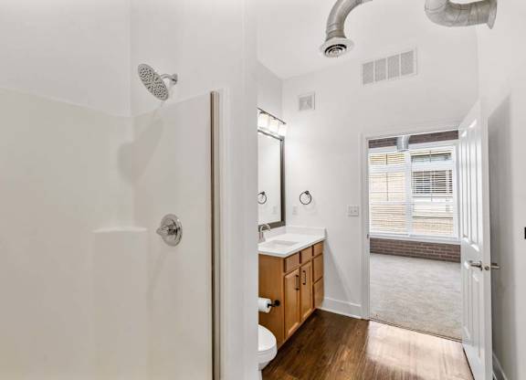 A bathroom with a walk in shower and a toilet.at The Foundry, South Bend Indiana