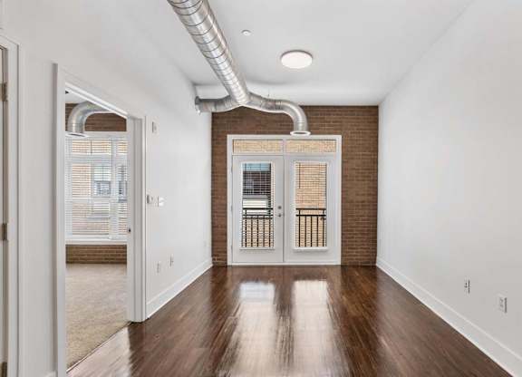 A room with a wooden floor and a white wall with a doorway leading to another room.at The Foundry, South Bend, IN 46617