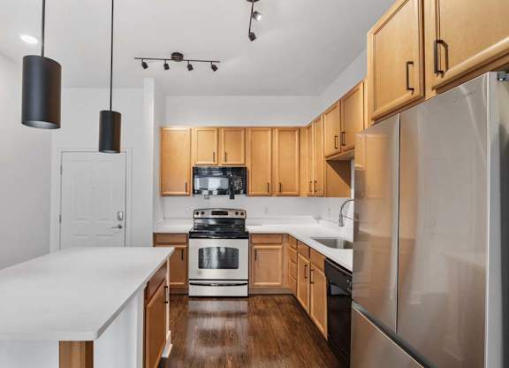 A modern kitchen with wooden cabinets and stainless steel appliances.at The Foundry, South Bend