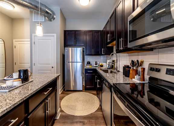 a kitchen with stainless steel appliances and granite counter tops at The Foundry, South Bend, IN 46617