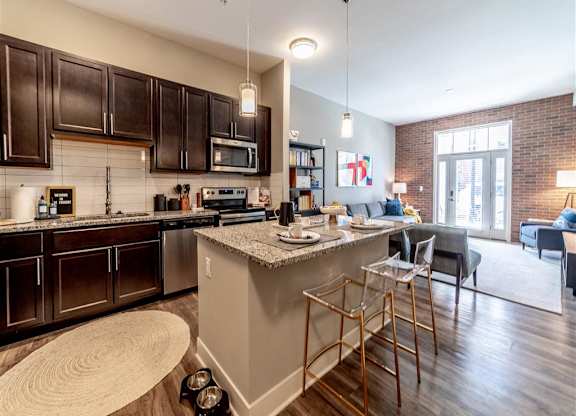 a kitchen with a bar and a living room at The Foundry, South Bend, IN
