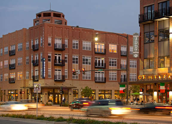 a large brick building on a city street with traffic at The Foundry, South Bend, IN 46617