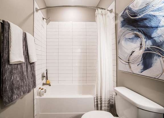 a bathroom with a white tub and a toilet at The Foundry, South Bend