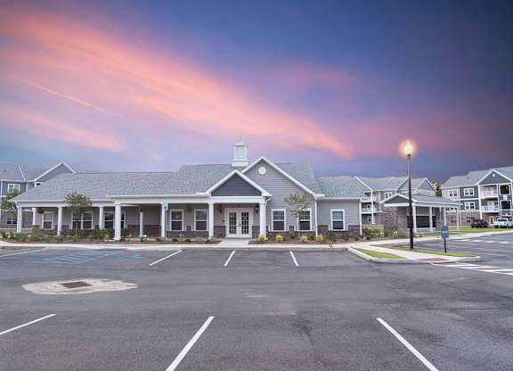 A parking lot in front of a building with a blue sky above.