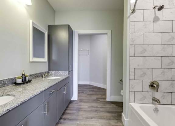 a bathroom with two sinks and a tub and a shower at Echo Park at Perry Crossing Apartments, Plainfield, IN