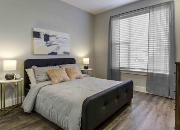 a bedroom with a bed and a large window at Echo Park at Perry Crossing Apartments, Plainfield, Indiana