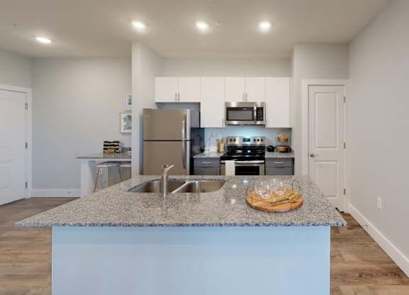 a kitchen with a granite counter top and a stainless steel refrigerator at Echo Park at Perry Crossing Apartments, Indiana, 46168