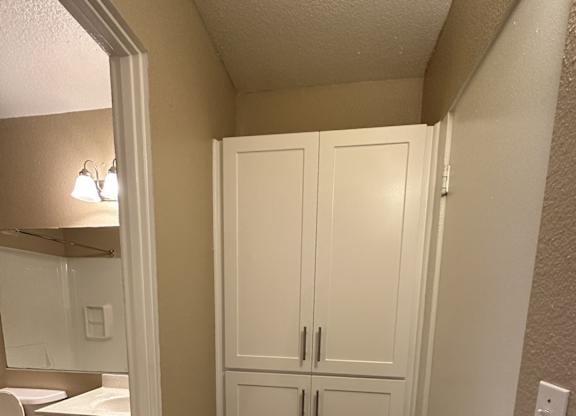 A white bathroom with a toilet, sink, and medicine cabinet.