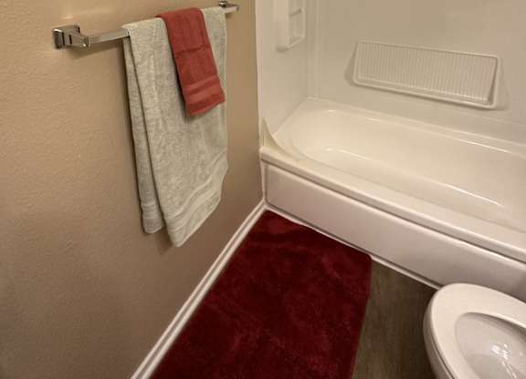 A bathroom with a red towel hanging on the towel rack.