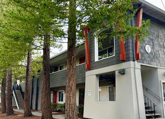 A grey building with a red trim and a clock on the side.