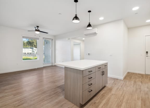 the living room and kitchen in a new home with white walls and wood flooring at 38° NORTH, Santa Rosa