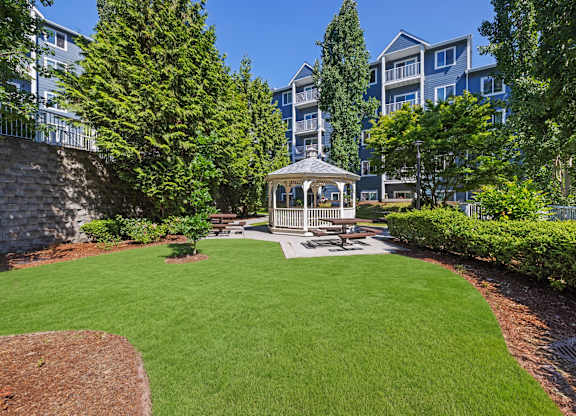 A gazebo sits in the middle of a grassy area.