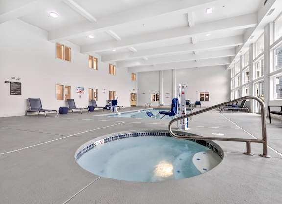 A large indoor swimming pool with a metal railing.