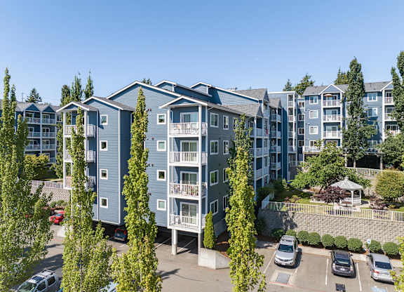 A large apartment complex with a parking lot in front.