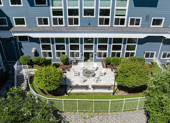 A large building with a courtyard surrounded by a white fence.