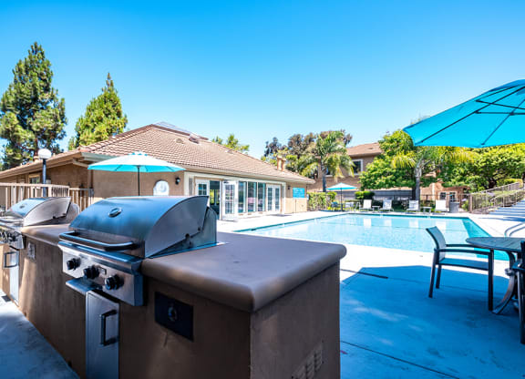 BBQ Area with Two Grills, Tables, Chairs, Umbrellas, and a Pool at BELLA VISTA AT HILLTOP, Richmond, 94806