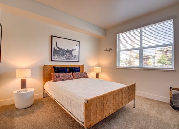 Spacious Bedroom With Carpet Flooring, A Bed, Nightstands With Lamps, And A Large Window With Blinds at 38° NORTH, Santa Rosa, 95404