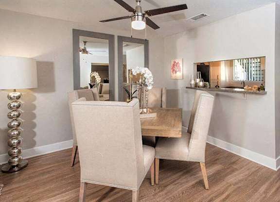 A dining room with a table and chairs.