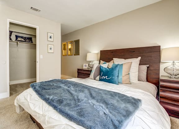 A bedroom with a bed covered in a blue blanket.