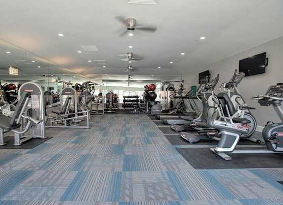 A gym with a variety of exercise equipment.