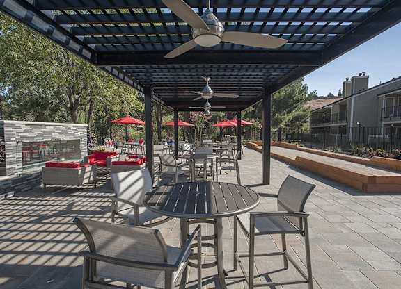 A patio with a table and chairs under a roof.
